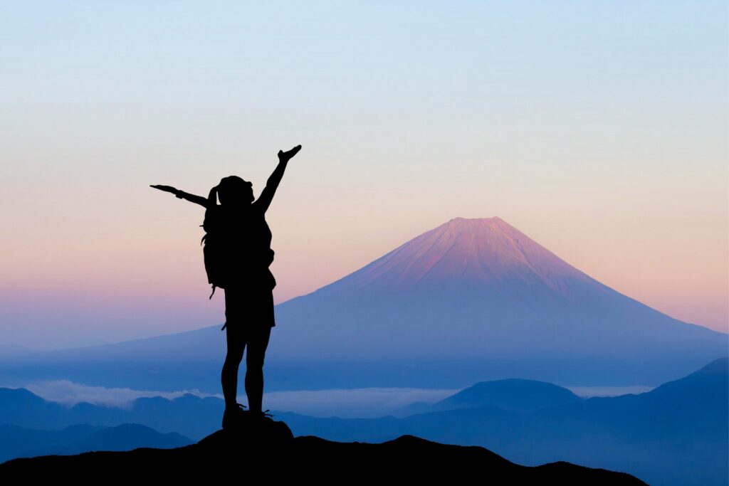 Woman standing with arms raised, symbolizing living life to the full