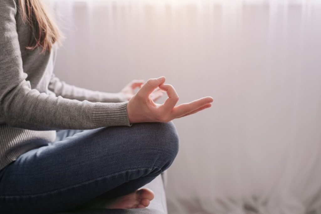 Woman sitting in yoga pose representing our Self-care Workshop on Meditation and Breathwork